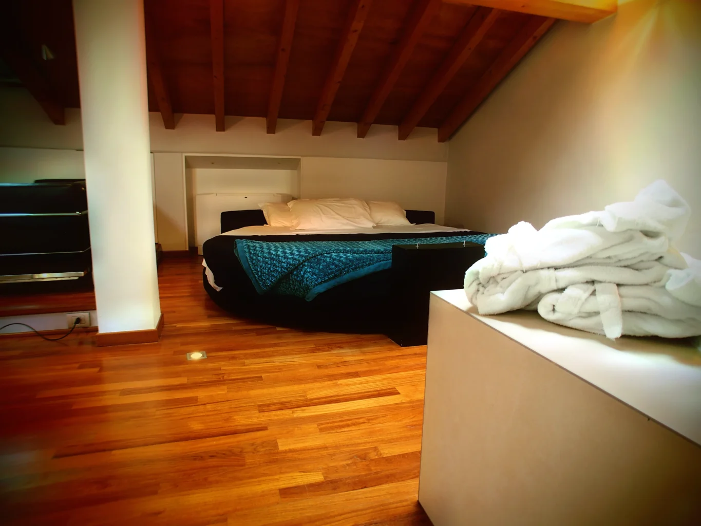 Suite Mansarda: letto rotondo sotto le travi a vista