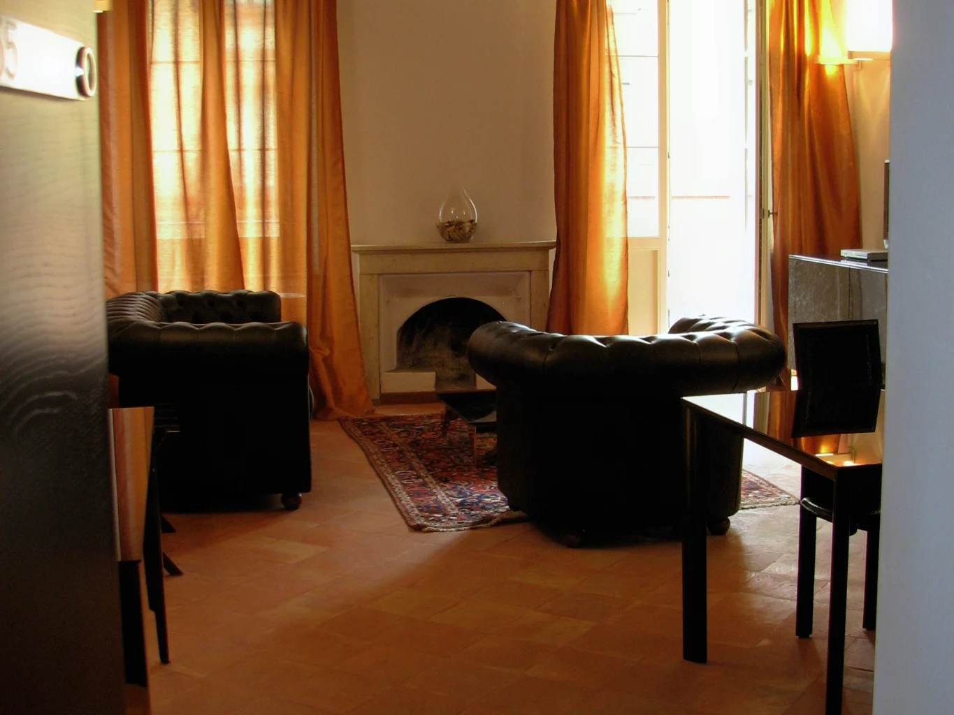 Suite 55: salotto con camino e poltrone in pelle